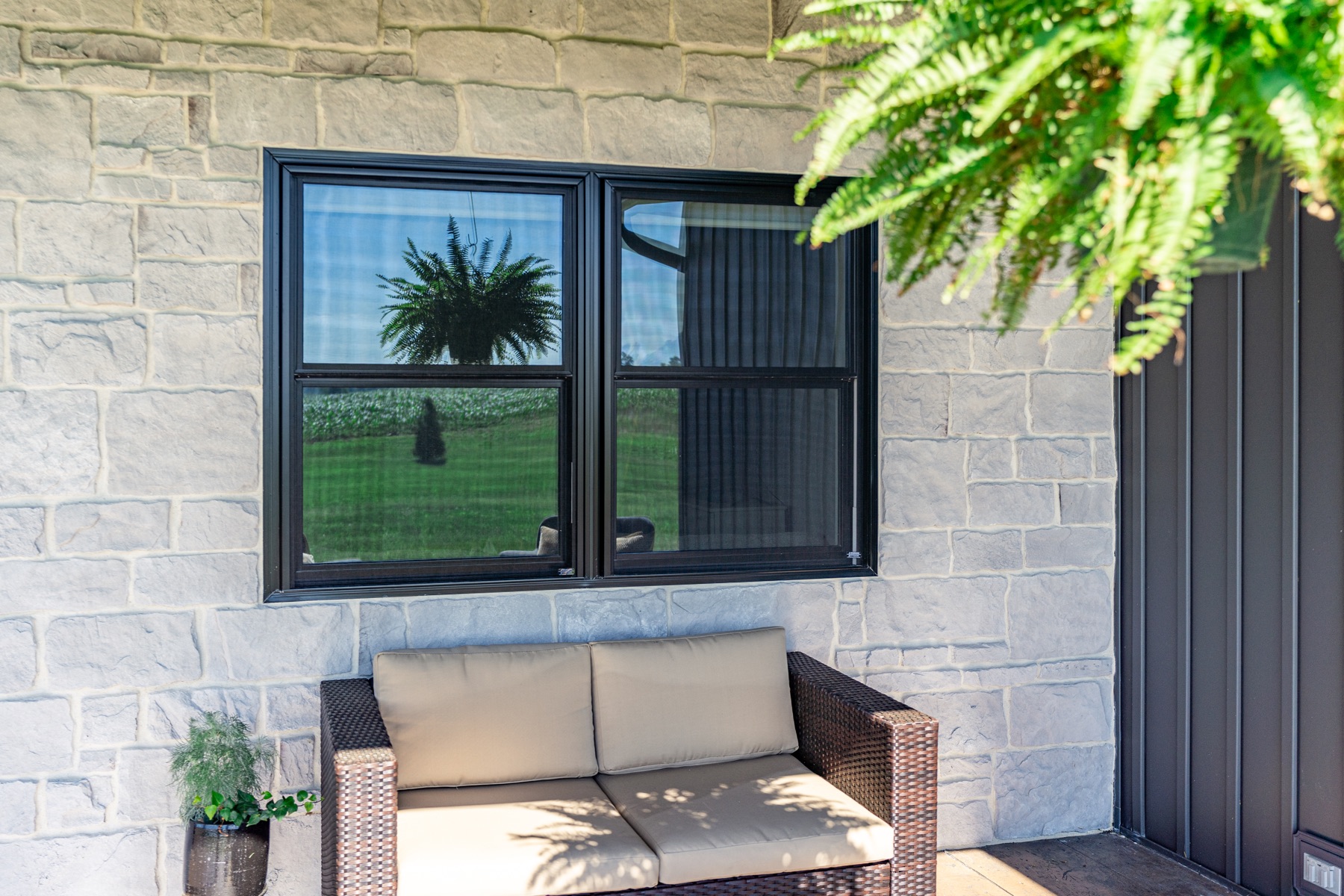 Black replacement windows on a stone exterior